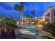 Backyard pool with a hot tub, string lights, patio and an exterior view of the home at night at 4594 Blue Mesa Way, Las Vegas, NV 89129