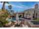 Backyard pool with a hot tub, palm trees, lounge chairs and well-manicured landscaping at 4594 Blue Mesa Way, Las Vegas, NV 89129