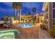 Backyard pool with a hot tub, lounge chairs, patio and an exterior view of the home at night at 4594 Blue Mesa Way, Las Vegas, NV 89129