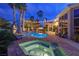 Backyard pool at night with a hot tub, string lights and lush, mature landscaping at 4594 Blue Mesa Way, Las Vegas, NV 89129