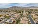 The aerial view shows houses with solar panels and desert landscaping against a mountain backdrop at 4624 Leon De Oro Dr, Las Vegas, NV 89129