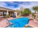 Backyard pool and lounge area surrounded by mature trees and desert landscaping at 4624 Leon De Oro Dr, Las Vegas, NV 89129