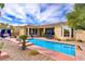 A long, sparkling pool with lounge area and desert landscaping with lush green trees at 4624 Leon De Oro Dr, Las Vegas, NV 89129