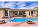 Backyard pool with a cascading water feature and lounge area with solar panels above at 4624 Leon De Oro Dr, Las Vegas, NV 89129
