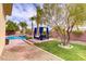 Expansive backyard oasis offering a pool, lounge area, and ample green space for relaxation and recreation at 4624 Leon De Oro Dr, Las Vegas, NV 89129