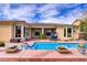 Backyard pool with a cascading water feature and lounge area in front of home at 4624 Leon De Oro Dr, Las Vegas, NV 89129