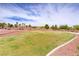 A well-kept community green space with lush grass and walking paths surrounded by mature landscaping and residences at 4624 Leon De Oro Dr, Las Vegas, NV 89129