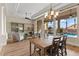 Open dining area with hardwood floors, decorative lighting, and views of the pool through expansive windows at 4624 Leon De Oro Dr, Las Vegas, NV 89129