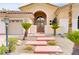 Charming home with stone steps, desert landscaping, a decorative front gate, and a three-car garage at 4624 Leon De Oro Dr, Las Vegas, NV 89129