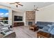 Cozy living room featuring a stone fireplace, ceiling fans, and ample natural light at 4624 Leon De Oro Dr, Las Vegas, NV 89129