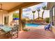 Inviting covered patio with dining, overlooking sparkling pool and mature landscaping at 4624 Leon De Oro Dr, Las Vegas, NV 89129