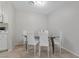 Bright dining area with a glass-top table and six white chairs, complemented by neutral walls at 4865 S Torrey Pines Dr # 206, Las Vegas, NV 89103