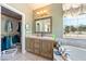 Bright bathroom with dual sink vanity, large mirror, soaking tub, and walk-in closet at 5081 Riata Pl, Pahrump, NV 89060