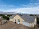 Home exterior with a two-car garage and solar panels, set against a scenic mountain backdrop at 5081 Riata Pl, Pahrump, NV 89060