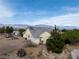 Charming single-story home with an attached garage, complemented by desert landscaping and mountain views at 5081 Riata Pl, Pahrump, NV 89060