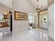Foyer with tiled floor, art on the wall, entry door, and a view into the kitchen at 5081 Riata Pl, Pahrump, NV 89060