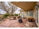 Covered outdoor patio area with stone flooring, lawn mower, outdoor table and access to the house at 5081 Riata Pl, Pahrump, NV 89060