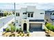 Contemporary two-story home boasting neutral stucco, an arched front entry, desert landscaping, and a two-car garage at 513 Monarch Ridge Ct, North Las Vegas, NV 89084