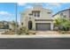 Two story home with modern design, desert landscaping and a gray garage door at 513 Monarch Ridge Ct, North Las Vegas, NV 89084
