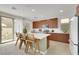 Modern kitchen features a center island with seating, wood cabinets, and access to outdoor patio at 513 Monarch Ridge Ct, North Las Vegas, NV 89084