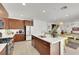 Modern kitchen features an island, stainless appliances, breakfast bar, and flows into the dining and living area at 513 Monarch Ridge Ct, North Las Vegas, NV 89084