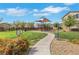 Community park featuring a playground and walking path, surrounded by lush green spaces and neighborhood homes at 513 Monarch Ridge Ct, North Las Vegas, NV 89084