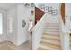 Bright staircase with white walls, wooden steps, gallery wall and half bath at 513 Monarch Ridge Ct, North Las Vegas, NV 89084