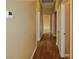 Hallway featuring wood floors, neutral-colored walls, and several white doors along the sides at 5236 Ladyhawk Way, Las Vegas, NV 89118