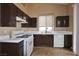 View of the kitchen featuring tile countertops, an electric stove, and dark wood cabinets at 5236 Ladyhawk Way, Las Vegas, NV 89118