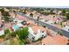 Birds eye view of a neighborhood with a pool in one of the backyards and terracotta roofs on the houses at 5609 Red Bluff Dr, Las Vegas, NV 89130