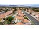 An elevated perspective of a community with terracotta roofs, featuring a pool and lush landscaping at 5609 Red Bluff Dr, Las Vegas, NV 89130