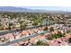 A picturesque aerial view of a residential neighborhood, showcasing a community with manicured lawns, golf course, and pond at 5609 Red Bluff Dr, Las Vegas, NV 89130