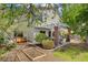 Landscaped backyard featuring a covered patio, seating, trees, and garden beds, creating a serene outdoor space at 5609 Red Bluff Dr, Las Vegas, NV 89130
