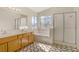 Bathroom featuring double sinks, a large tub below sunlit windows, and glass shower doors at 5609 Red Bluff Dr, Las Vegas, NV 89130