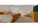 Bright bedroom features a large bed, glider and dresser with television, and large windows at 5609 Red Bluff Dr, Las Vegas, NV 89130