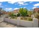 Well-maintained home with stucco walls, a three-car garage, mature landscaping, and a decorative wrought iron fence at 5609 Red Bluff Dr, Las Vegas, NV 89130
