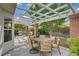 Covered patio area with a pergola, string lights, brick pillars, and a dining table for outdoor entertaining at 5609 Red Bluff Dr, Las Vegas, NV 89130