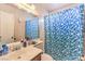 Bathroom with a shower, standard vanity, tile flooring and a blue and white shower curtain at 5809 Robin Ln, Las Vegas, NV 89108