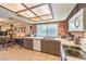 Kitchen and eat-in area features tile flooring, brick wall, brown cabinetry, and plenty of lighting at 5809 Robin Ln, Las Vegas, NV 89108