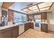 Traditional kitchen features brick wall, tile flooring, brown cabinetry, and a window for natural lighting at 5809 Robin Ln, Las Vegas, NV 89108