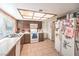 Traditional kitchen features brick wall, tile flooring, brown cabinetry, and a window for natural lighting at 5809 Robin Ln, Las Vegas, NV 89108