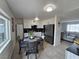 Eat-in kitchen with stainless steel appliances and black countertops adjacent to the living room at 6212 Burgundy Way, Las Vegas, NV 89107