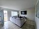 Bright living room showcasing tile flooring, a large TV, and a comfortable gray sectional sofa at 6212 Burgundy Way, Las Vegas, NV 89107