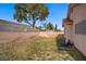 Fenced backyard with desert landscaping and mature trees, providing shade at 6332 Sierra Pines Ct, Las Vegas, NV 89130