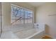 Bathroom with a soaking tub, tile floors, and a large window overlooking the backyard at 6332 Sierra Pines Ct, Las Vegas, NV 89130
