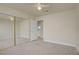 Bedroom showcasing carpet, ceiling fan, and mirrored closet, offering a view of laundry area and access to more rooms at 6332 Sierra Pines Ct, Las Vegas, NV 89130