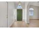 Welcoming foyer with a green front door, arched window and wood laminate flooring at 6332 Sierra Pines Ct, Las Vegas, NV 89130