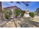 Exterior view of cozy home surrounded by mature trees and lush lawn on a sunny day at 6332 Sierra Pines Ct, Las Vegas, NV 89130