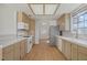 Spacious kitchen with tile counters, stainless steel refrigerator, and view of an adjacent room at 6332 Sierra Pines Ct, Las Vegas, NV 89130
