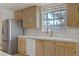 Kitchen featuring stainless steel refrigerator, tile counters, and bright window at 6332 Sierra Pines Ct, Las Vegas, NV 89130